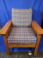 Front view with cushions showing plaid upholstery and oak frame