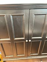 Front view showing two paneled doors and knob handles