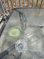 Group shot of three glass ashtrays/dishes and Denver Broncos bottle on glass table