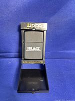 Black Zippo lighter The Black logo in open display case