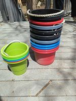 Stack of 10 larger buckets and stack of 5 smaller buckets showing colors and rope handles
