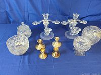 Group shot of all items: glass candelabras, sterling candlesticks, cut glass dishes and globe