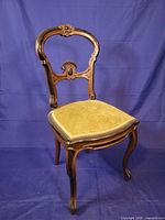 Full view of carved mahogany chair showing backrest and upholstered seat