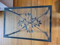 Top view of rectangular glass table with leaf design visible through glass