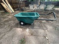 side view of green plastic garden cart showing two wheels and pull handle