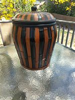 Closed basket on glass table showing striped body and lid