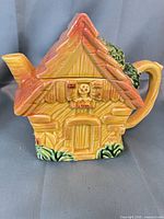 Front view of cottage-shaped ceramic teapot