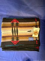 Both folded Pendleton blankets showing pattern and size