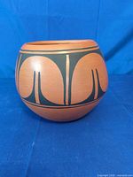 Front view of rounded terracotta bowl with black geometric design