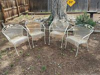 All four metal patio chairs arranged outdoors