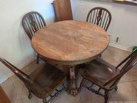 Round oak table with four chairs around it