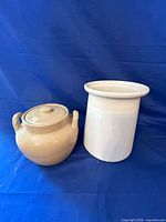 White crock and cream lidded pot side by side