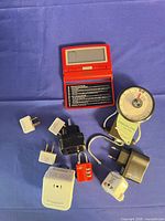 Group shot showing alarm clock, adapters, converter and luggage scale