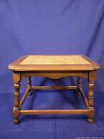 Full view of rectangular wooden side table, tile inset top, turned legs, stretchers visible
