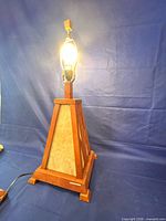 Lamp base showing wood frame and cream glass panels illuminated