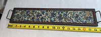 Full view of framed embroidery with tape showing overall length ~19 in