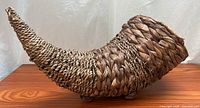Side profile of cornucopia wicker basket on wood surface