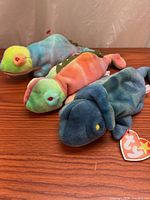 Three Ty Beanie Baby lizard plush toys on table