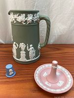 Front view of olive green jasper jug, pink ring holder, blue thimble