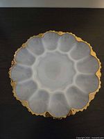 Top view showing egg wells, center section, and gold-trimmed scalloped rim
