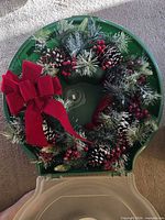 Wreath inside open green plastic case showing decoration details
