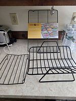 Group of four black wire racks on countertop