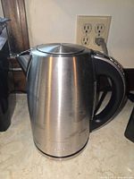 Front side of stainless steel electric kettle showing brushed metal body and spout