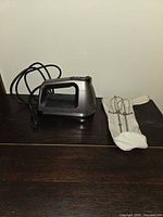 Hand mixer body and beater sleeve on dark surface