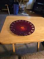 Front of red Fenton basket weave glass plate on table