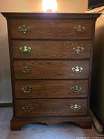 Front view of tall five-drawer chest showing hardware and molding