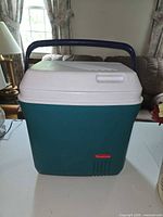 Front view of teal Rubbermaid cooler with handle down