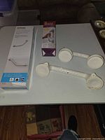 Moen boxed grab bar with two white suction grab handles
