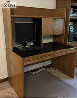Front view of Sauder desk showing monitor bay, upper cabinet, black desktop surface