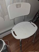 Front view of shower chair showing seat, backrest, legs and handles