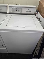 Front view of Speed Queen top-load washer alongside another appliance