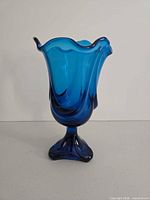 Front view of blue swung pedestal vase