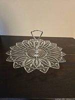 Top view of clear glass tray showing Petal starburst pattern and handle