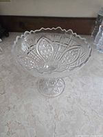 Top view of clear pressed glass compote showing scalloped rim and interior pattern