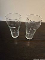 Front view of both Libbey Coca-Cola glasses showing white “Coke” logo