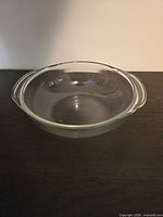 Top angled view of clear glass round casserole dish with handles
