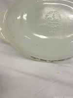 Base stamp of white milk glass casserole showing Anchor Hocking Fire-King mark