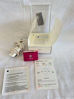 iPod Shuffle, dock with cable, box, manuals displayed