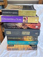 Stack of seven paperback books showing all spines and titles