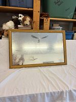 Front view showing gold-tone wooden frame and aged mirror surface