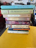 Full stack of eight books showing spines and authors