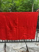 Full view of red wool blanket hung outdoors