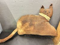 Front view of brown stuffed cat pillow with face and scarf