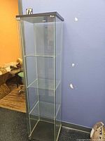 Full front view of glass display cabinet showing overall design and three interior shelves
