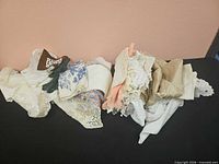 Stacked assorted linens in various colours and textures