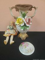 Group shot showing vase, plate and doll